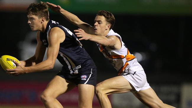 Mitch Podhajski lays a tackle on Geelong Falcons Adam Garner. Picture: Alison Wynd.