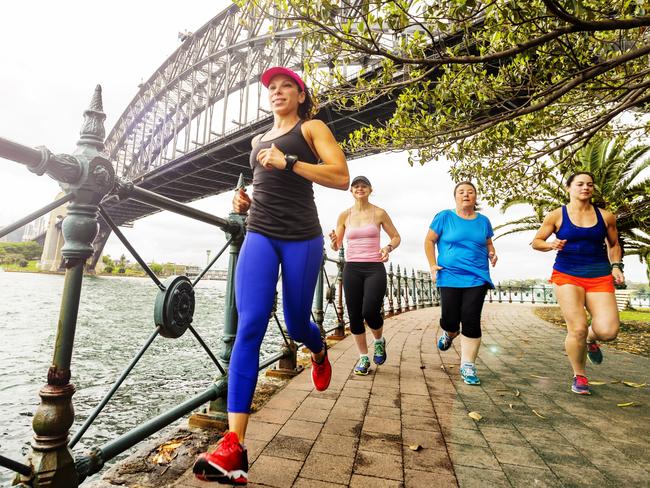 Group of women running under stormy skies.