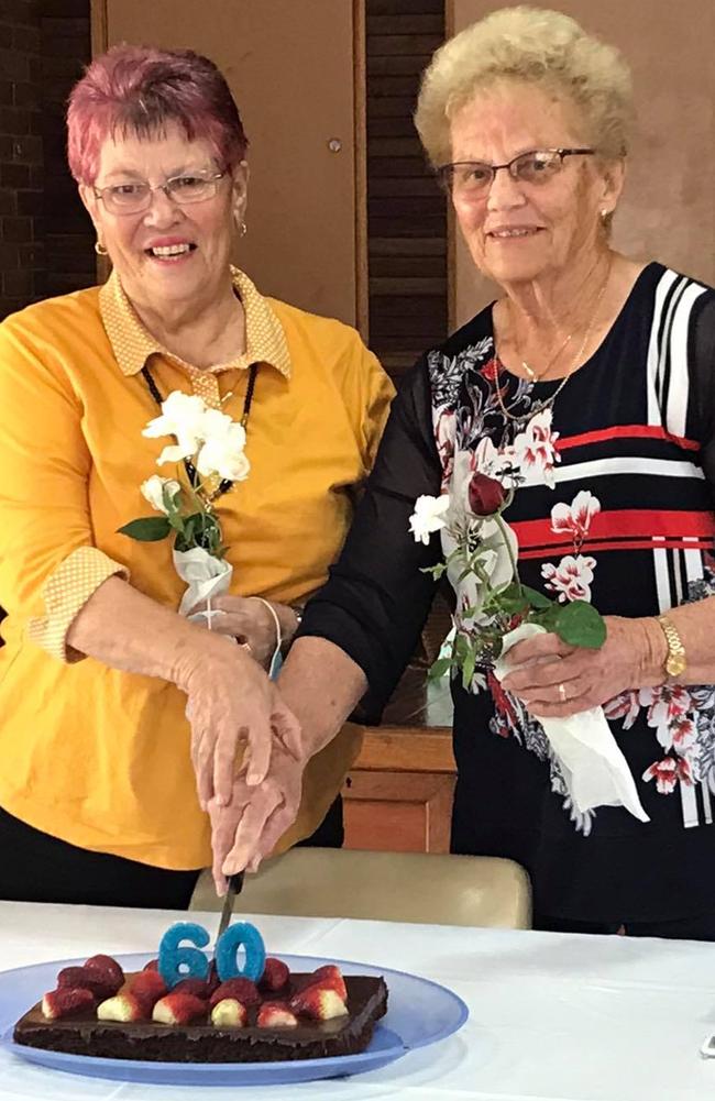 Patricia Keys Ballard and fellow parishioner Fay Jordan share a cake to celebrate each of their 60-year marriages.