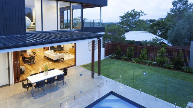 A frameless glass pool fence offers a seamless transition from pool to entertaining area