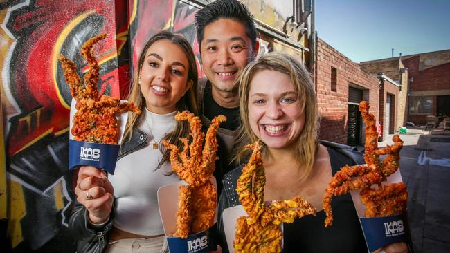 IKA8 head chef Eddie Huynh shows off his tasty squid treats with Alexia Brehas and Bella Grabowsky. Picture: Nicole Cleary