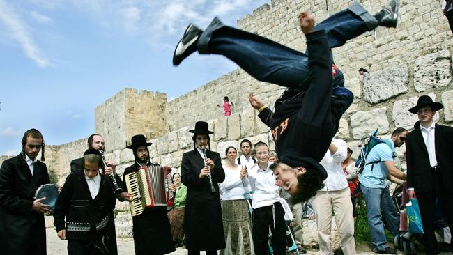 Ultra Orthodox Jewish Klezemer band members play music and dance next to the walls of Jerusalem old city during the Jewish Passover.