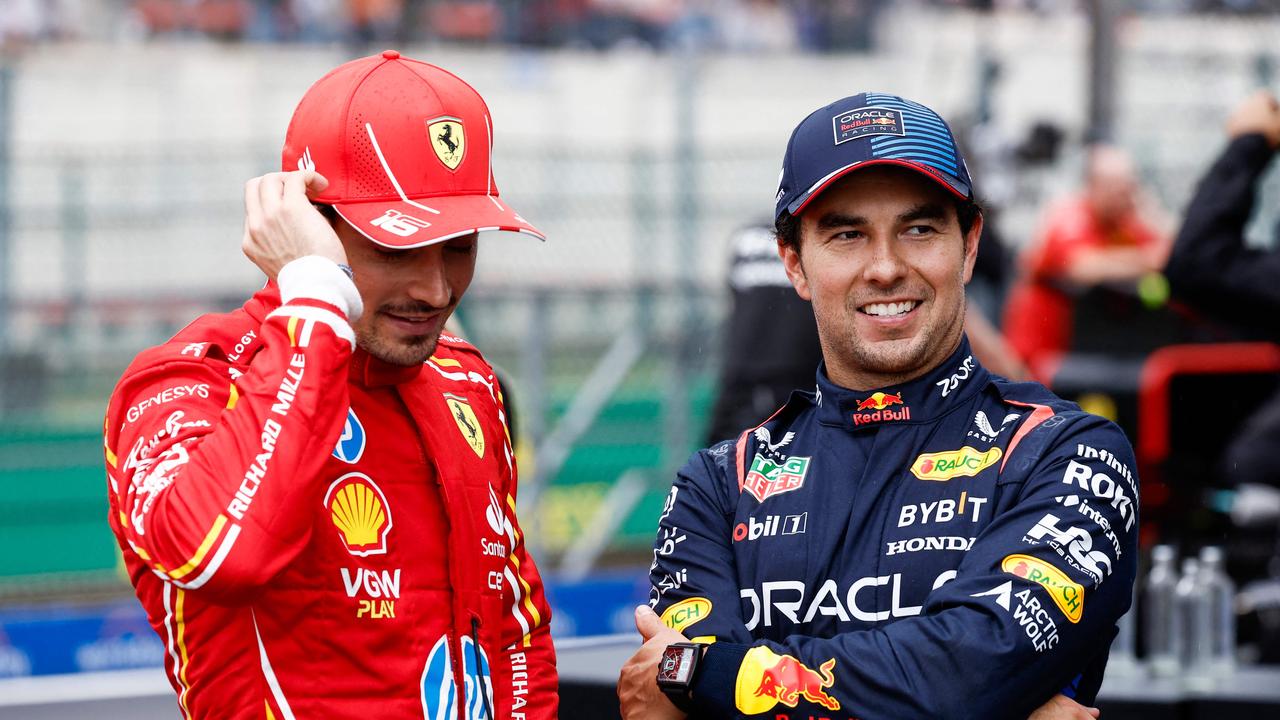 Ferrari's Monegasque driver Charles Leclerc (L) speaks with Red Bull Racing's Mexican driver Sergio Perez.