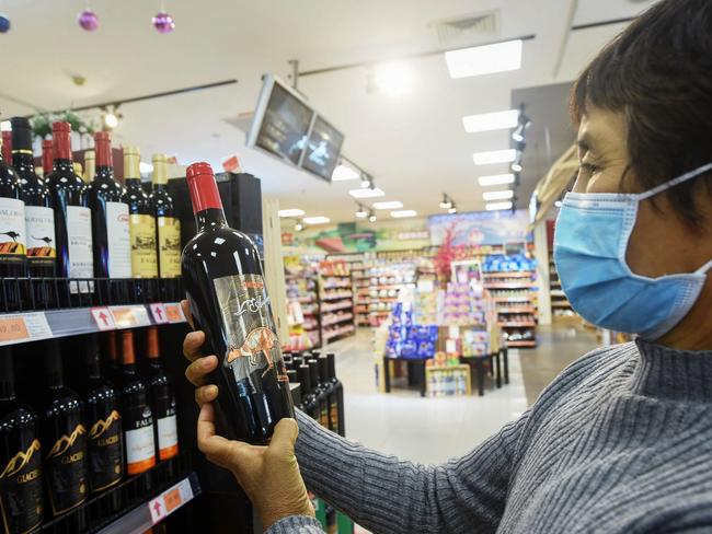 A woman looks at a bottle of Australian wine at a supermarket in China. Picture: AFP