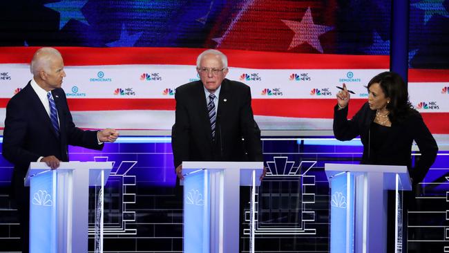 MIAMI, FLORIDA - JUNE 27: Sen. Kamala Harris (R) (D-CA) and former Vice President Joe Biden (L) speak as Sen. Bernie Sanders (I-VT) looks on during the second night of the first Democratic presidential debate on June 27, 2019 in Miami, Florida. A field of 20 Democratic presidential candidates was split into two groups of 10 for the first debate of the 2020 election, taking place over two nights at Knight Concert Hall of the Adrienne Arsht Center for the Performing Arts of Miami-Dade County, hosted by NBC News, MSNBC, and Telemundo.   Drew Angerer/Getty Images/AFP == FOR NEWSPAPERS, INTERNET, TELCOS & TELEVISION USE ONLY ==