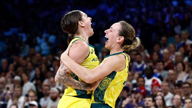 Australia's #15 Cayla George (C-L) and teammates celebrate after Australia won the women's preliminary round group B basketball match between Australia and France during the Paris 2024 Olympic Games at the Pierre-Mauroy stadium in Villeneuve-d'Ascq, northern France, on August 4, 2024. (Photo by Sameer Al-Doumy / AFP)