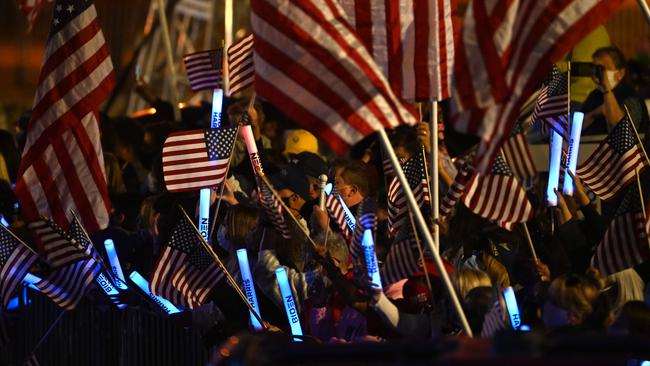 Supporters of US President-elect Joe Biden and Vice President-elect Kamala Harris wave flags as they wait for them to arrive to speak in Wilmington, Delaware after being declared the winners of the presidential election. Picture: AFP