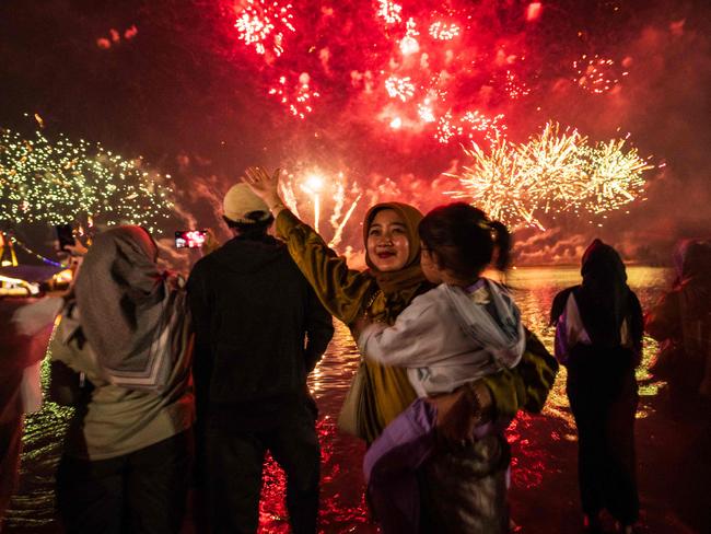 Local residents look at fireworks as they celebrate the New Year at Ancol Beach in Jakarta on January 1, 2025. Picture: AFP