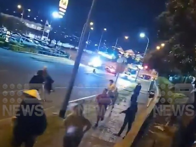 A large crowd pictures on the road outside the McDonald's at Christine Ave in Robina on Saturday May 6 as police conducted an operation targeting hoons in the area. Picture: Nine Gold Coast News.