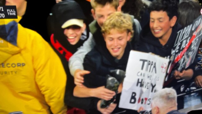 Bombers fans Billy White (holding Tippa's boots) and Sacha Demetriou (right). Picture: Channel 7