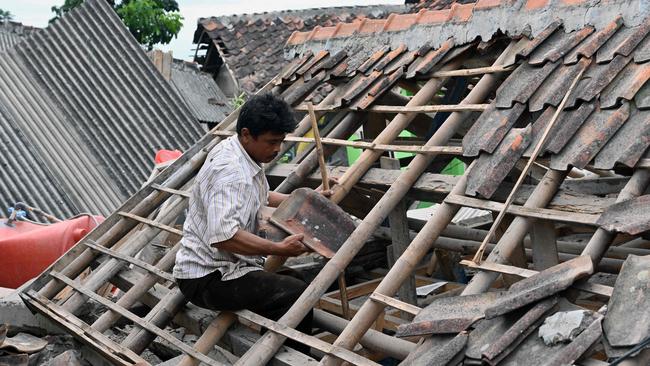 A man sifts through the rubble of a collapsed house in Cugenang, Cianjur on November 23, 2022, following a 5.6-magnitude earthquake on November 21. Picture: AFP