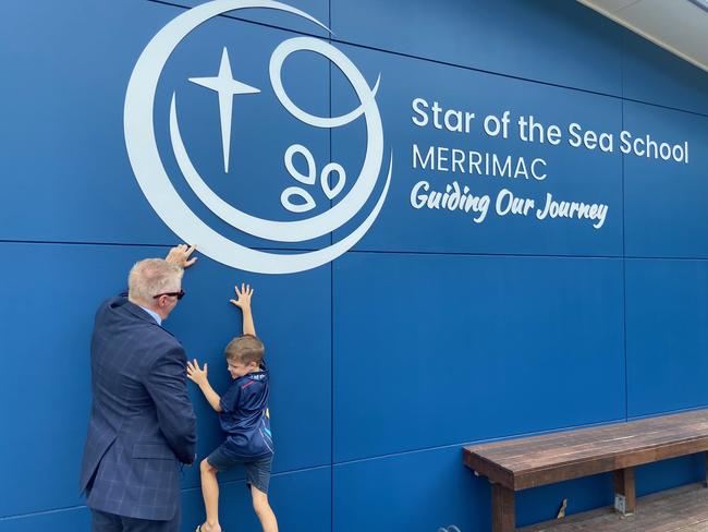 Star of the Sea School student Peyton Eslick checks out the new school sign with Principal Tony Barron.