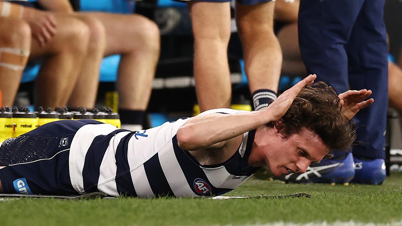 Max Holmes of the Cats hits the ground after injuring his hamstring