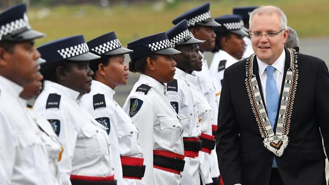 Scott Morrison (right) is seen inspecting an honour guard of the Royal Solomon Islands Police Force after arriving at Honiara International Airport. Picture: AAP