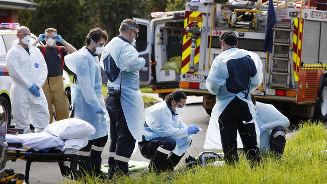 Paramedics and MFB firefighters wear protective PPE, while trying to save a young woman from a suspected drug overdose. Picture: David Caird