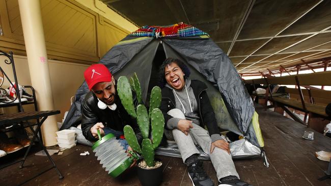 Squatters Victor Aguilera and Pearl Garling water their cactus as they make themselves a home in the grandstand. Picture: David Caird