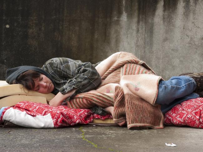 Homeless woman lying on the street.