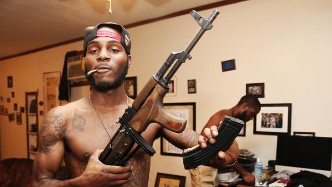 Ace loads an AK-47 assault rifle inside his home in New Orleans. Picture: Gary Ramage