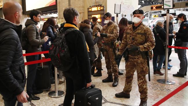 Police officers and soldiers check passengers leaving Milan main train station. Picture: AP.