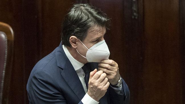 Italian Premier Giuseppe Conte adjusts his face mask as he arrives at paliament on Tuesday. Picture: AFP.