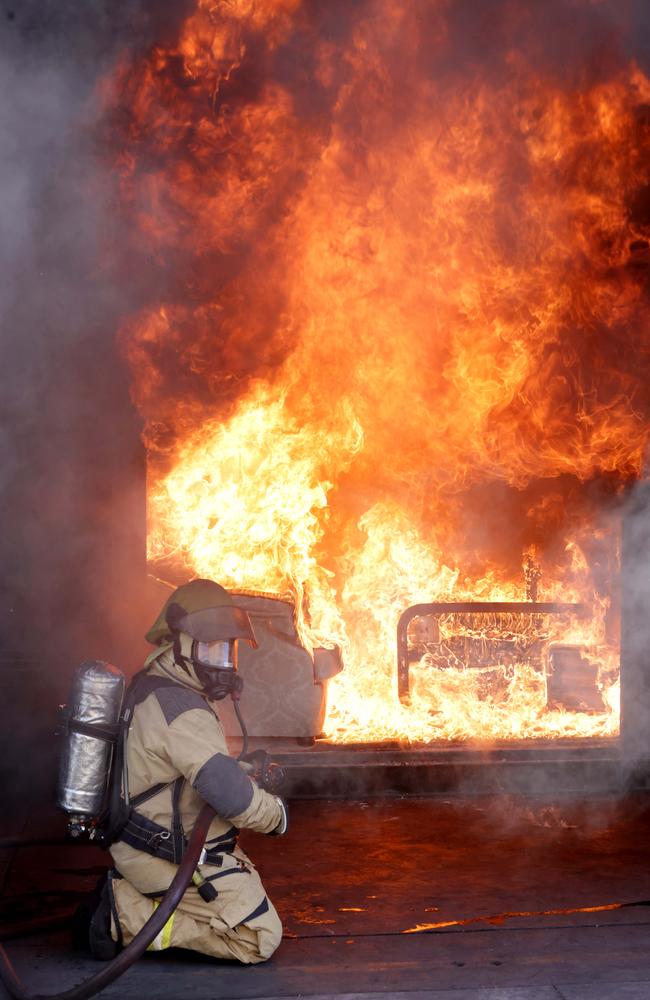 Station Officer Andrew Crane putting out a demonstration of a bedroom fire which started from a heater. Photo Steve Pohlner