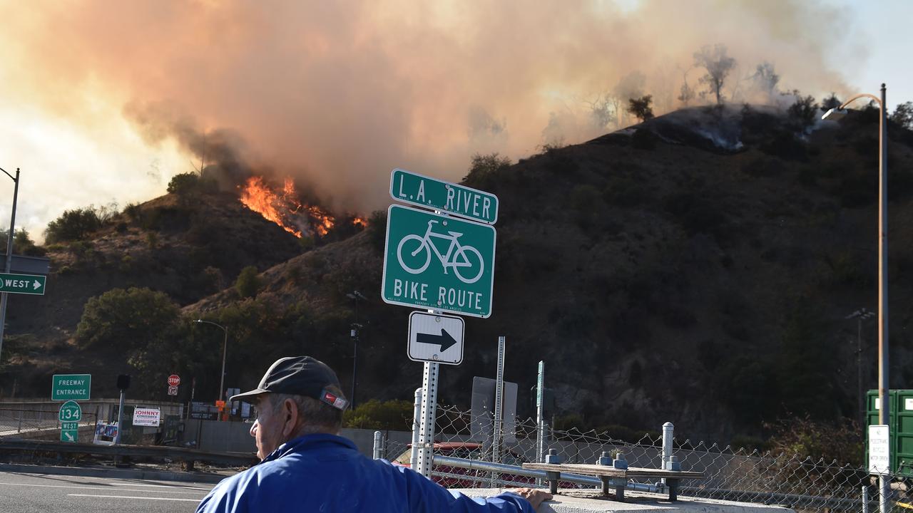 A man watches flames from a wildfire in Griffith Park in Los Angeles. Staff at the Los Angeles Zoo, which is located in the park are preparing animals to be evacuated. Picture: Robyn Beck/AFP