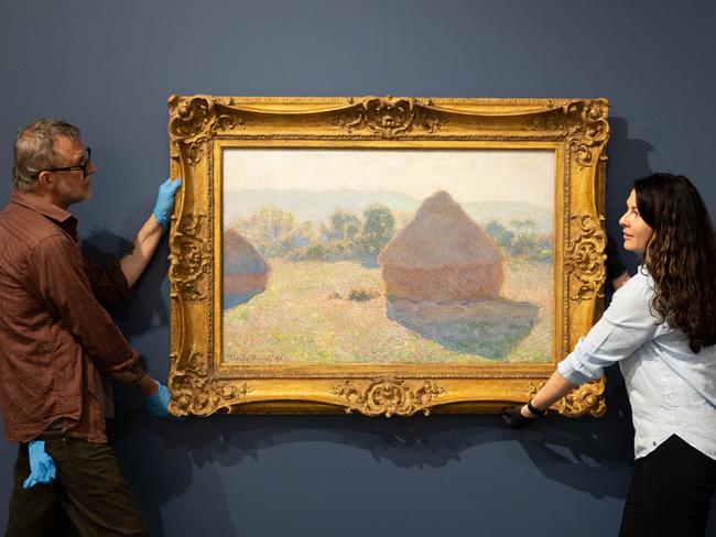 Art technician Chas Glover and Tweed Regional Gallery Curator - Exhibitions Tina Wilson hanging Claude Monet's masterpiece Meules, milieu du jour [Haystacks, midday], 1890, on November 1, 2023 as part of the National Gallery of Australia's Sharing the National Collection Initiative. Picture: Luke Marsden/ Tweed Regional Gallery.