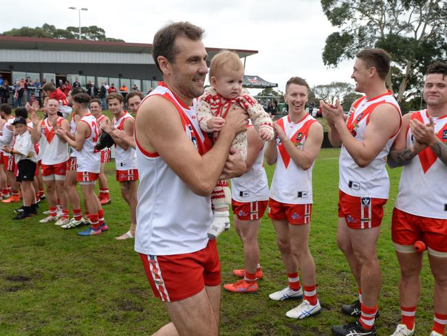 Karingal champion Luke Van Raay runs out for his 300th game, accompanied by his daughter Elle. Picture: Chris Eastman