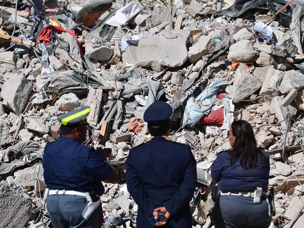 AMATRICE, ITALY - AUGUST 25: Police officers view the remains of a building that was destroyed during an earthquake, on August 25, 2016 in Amatrice, Italy. The death toll in the 6.2 magnitude earthquake that struck around the Umbria region of Italy in the early hours of Wednesday morning has risen to at least 247 as thousands of rescuers continue to search for survivors. (Photo by Carl Court/Getty Images)