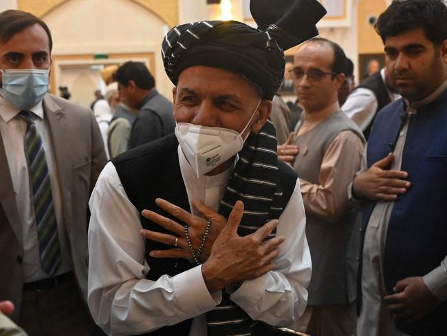 Afghanistan's President Ashraf Ghani (C) greets people before addressing a function at the Afghan presidential palace in Kabul on August 4, 2021. (Photo by SAJJAD HUSSAIN / AFP)