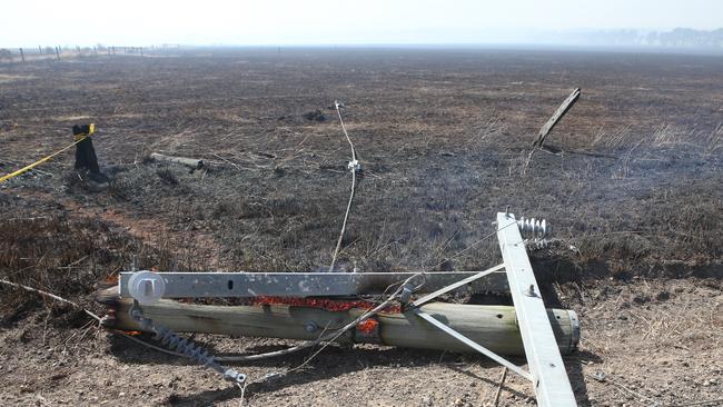 A power pole burns on the ground near Cobden. Picture: AAP Image/David Crosling