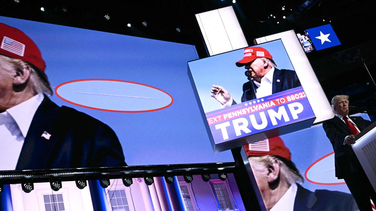 A photo showing a bullet going past Donald Trump's head during an assassination attempt is shown on screen during the 2024 Republican National Convention in Milwaukee, Wisconsin. (Photo by Brendan SMIALOWSKI / AFP)