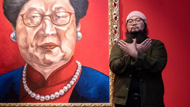 Chinese dissident artist Badiucao poses next to his artwork entitled Carrie Lam, 2018, at the exhibition China is (not) near -- works of a dissident artist, in Brescia, Lombardy. Picture: AFP