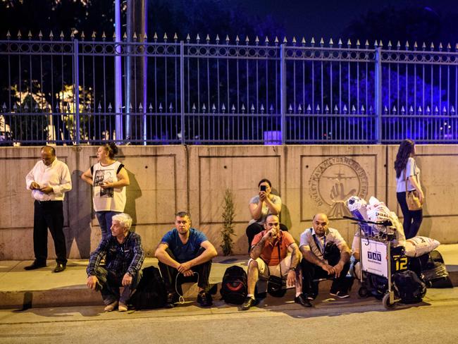 People wait with their luggage outside the Ataturk airport in Istanbul. Picture: AFP/Ozan Kose