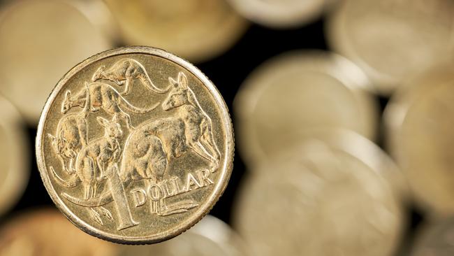 Australian one dollar coin over blurred golden background.