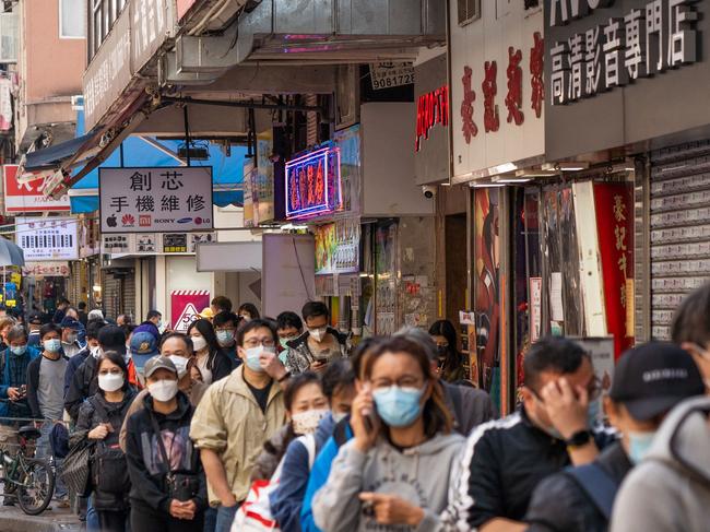 People queue on a street for Covid-19 test kits in Hong Kong’s Sham Shui Po area on February 27, 2022, as a record high number of new Covid-19 infections were recorded in the city. Picture: Bertha Wang / AFP.