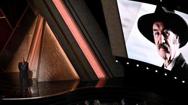 An image of Gene Hackman is displayed on a screen as Morgan Freeman pays tribute. Picture: AFP