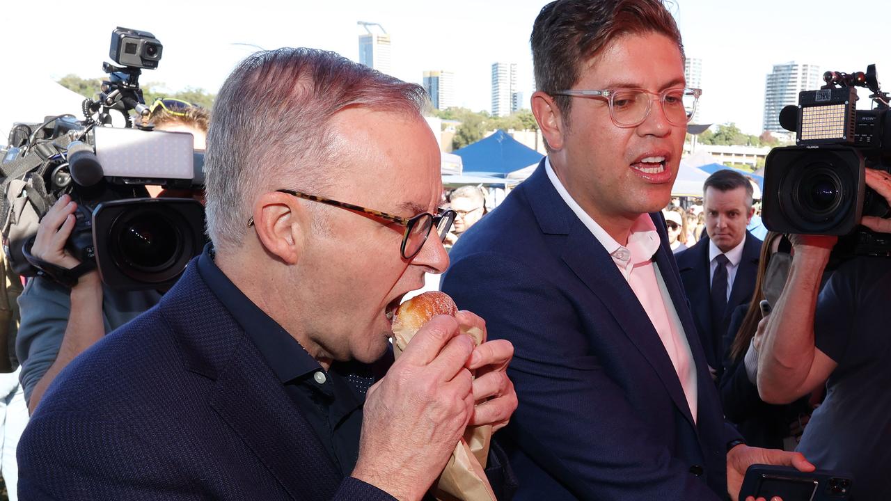 Labor leader Anthony Albanese samples a rhubarb doughnut during his visit to Ryde Wharf Market on Sunday with Bennelong candidate Jerome Laxale. Picture: Liam Kidston