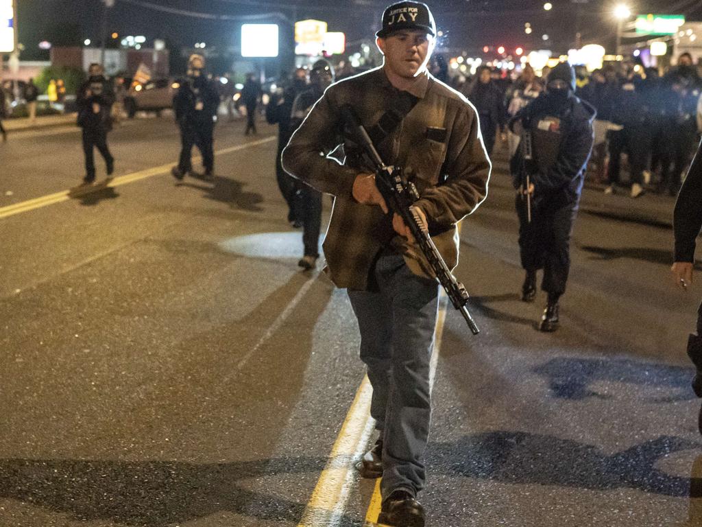 Patriot Prayer member Chandler Pappas carries an assault rifle while walking through a crowd of Black Lives Matter protesters in Vancouver, Washington on October 30. Picture: Nathan Howard/Getty Images/AFP