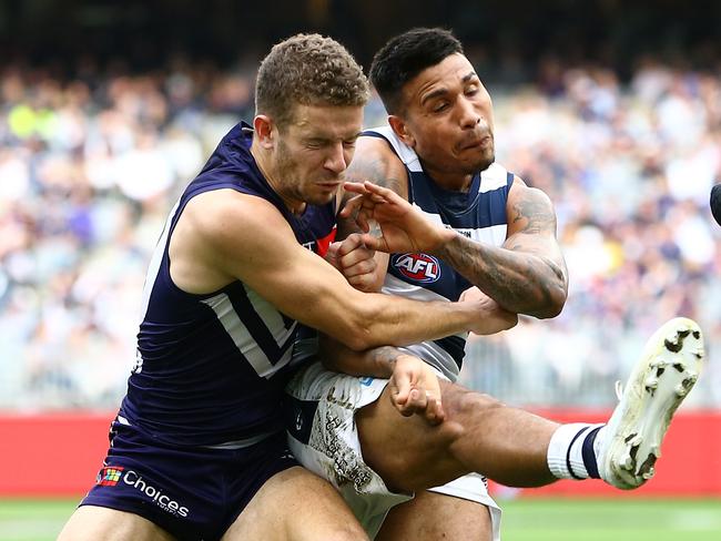 Tim Kelly of the Cats kicks forward under pressure from Sam Switkowski and Nat Fyfe of the Dockers during the Round 20 AFL match between the Fremantle Dockers and the Geelong Cats at Optus Stadium in Perth, Saturday, August 3, 2019.  (AAP Image/Gary Day) NO ARCHIVING, EDITORIAL USE ONLY