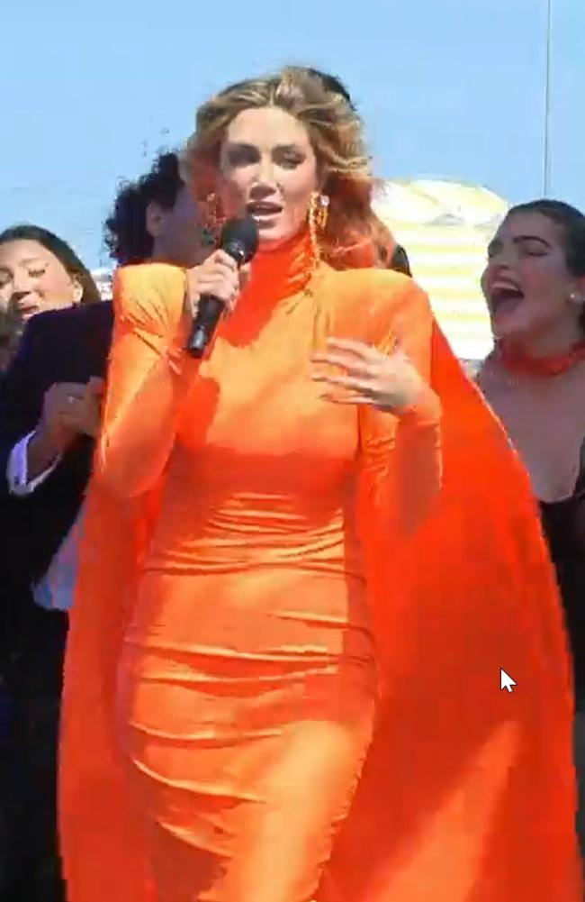 Delta Goodrem has surprised viewers by changing into a bright orange gown with a billowing cape to perform at the 2021 Melbourne Cup. Picture: Channel 10