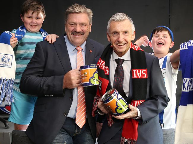 Channel 7 commentator Brian Taylor with Bruce McAvaney and North Melbourne and Kangaroo supporters Cooper and Archer. Picture: Michael Klein