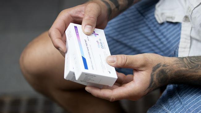 A customer holds his (RAT) rapid antigen tests after purchasing them from a chemist in Sydney. Picture: NCA NewsWire / Nikki Short