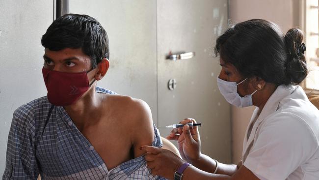 A health worker inoculates a college student against Covid-19 in Bangalore, India, where food incentives and vaccination ‘camps’ ensure greater coverage. Picture: Manjunath Kiran/AFP