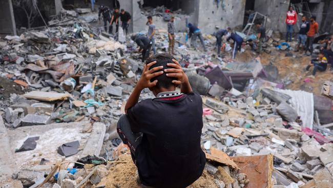 A child reacts as people salvage belongings amid the rubble of a damaged building following strikes on Rafah in the southern Gaza Strip. Picture: AFP