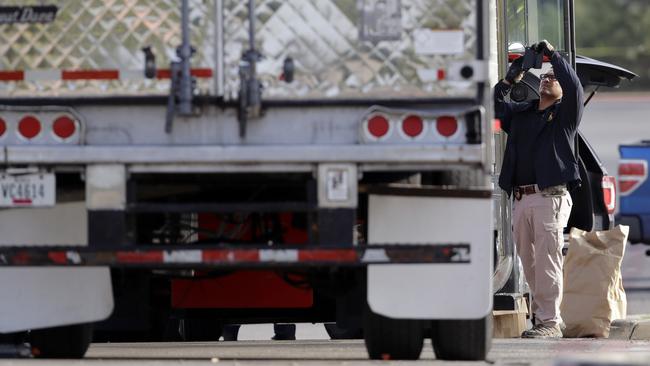 Evidence is collected at the scene where people were found dead in a tractor-trailer loaded with multiple others, outside a Walmart store in San Antonio. Picture: Eric Gay/AP