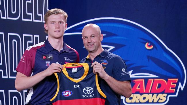 Fischer McAsey is presented with a jersey by Adelaide Crows coach Mathew Nicks during the first round of the 2019 AFL Draft. (AAP Image/Michael Dodge) NO ARCHIVING