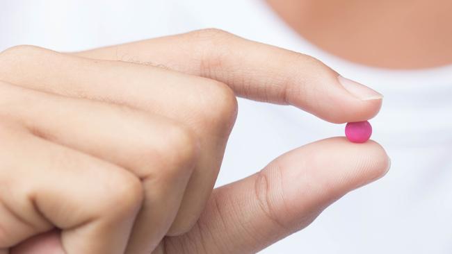 SAW Pink Pill - April 15, Medicine pills in hand, selective focus - StockMedicine pills in hand , selective focus