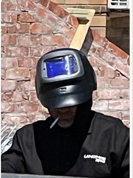 Mike Arnold smoking while wearing a welding mask, earning him the nickname Dart Vader.