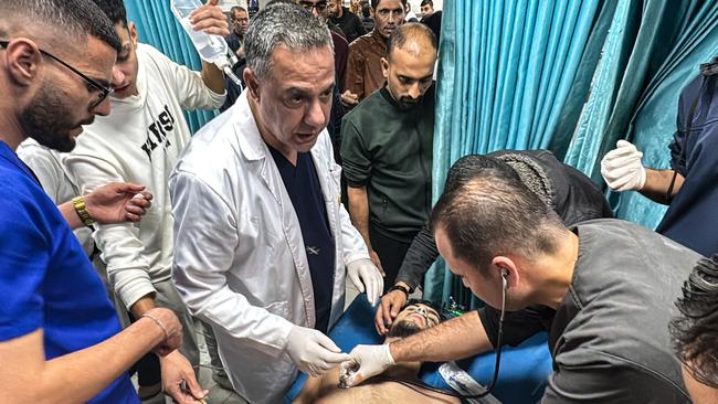 (FILES) Hossam Abu Safieh (C), director of the Kamal Adwan Hospital, supervises the treatment of a Palestinian man,  injured in an Israeli strike on Beit Lahia in the northern Gaza Strip on November 21, 2024. Detained on suspicion of being a Hamas militant, Hossam Abu Safiyeh, head of a major hospital in Gaza that was raided by Israeli forces last week, has become the face of a crumbling healthcare system in the war-ravaged Palestinian territory. (Photo by AFP)